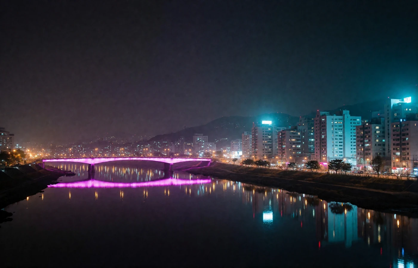 Night view of a Korean capital riverfront with an illuminated bridge and glowing high-rise districts along the water