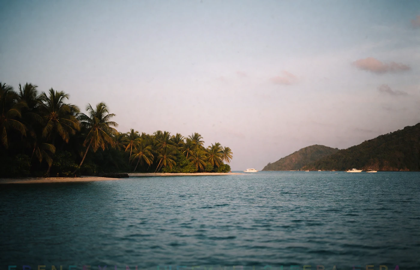 Tropical Sri Lankan coastline at dusk with palm-fringed headlands along calm turquoise water